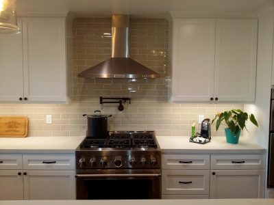 White kitchen with stainless steel hood